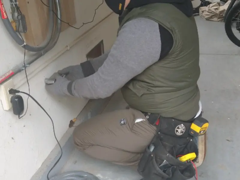 Electrician performing outlet wiring in a Riverview garage